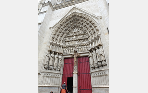 Patrick est tout petit devant la porte d'entrée de la cathédrale d'Amiens